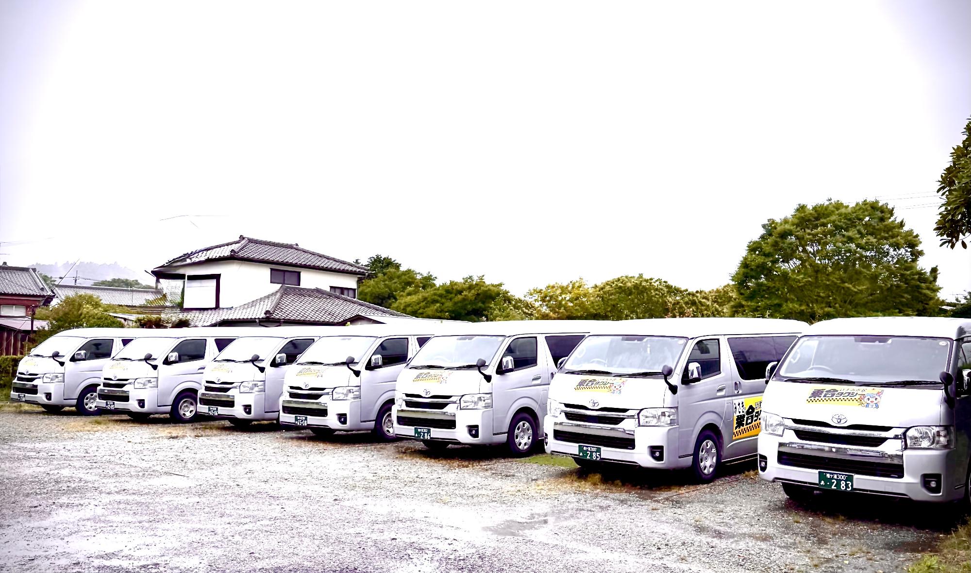 乗合タクシーの車両が7台並んでおり、正面左斜め前から全体が写るように撮影した写真
