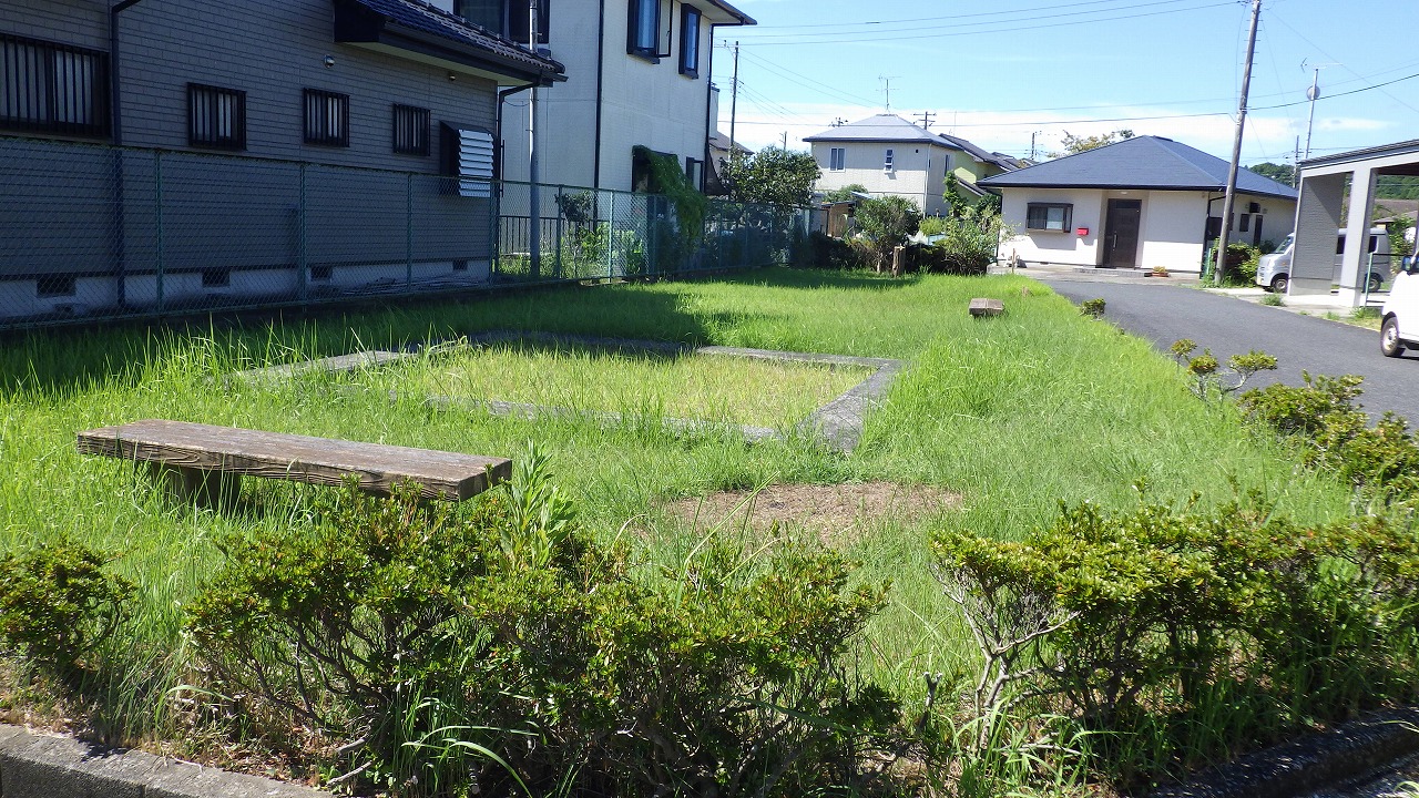 蔵屋敷公園の全体写真。芝生が広がっており、ベンチが2つあります。