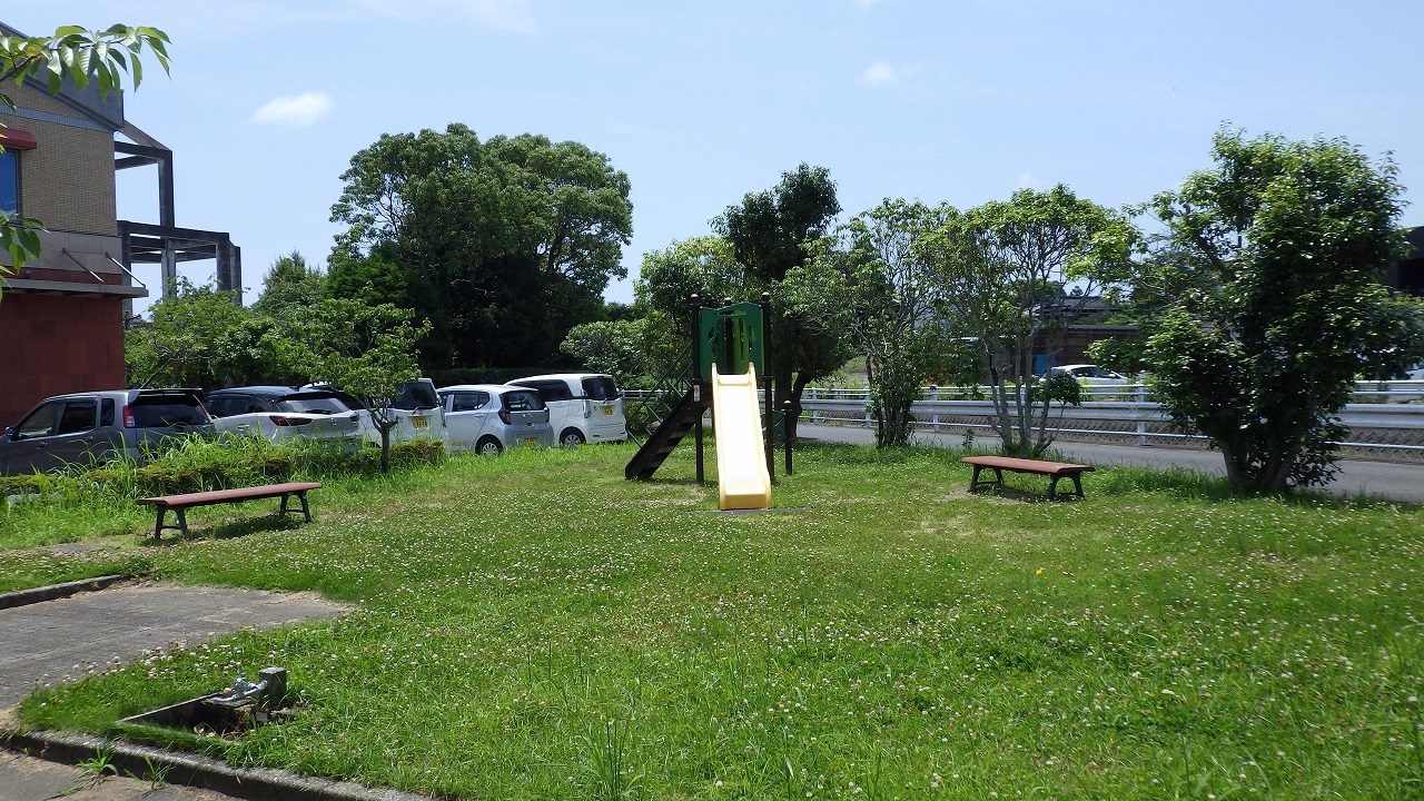 岬ふれあい会館の写真です。芝の上にすべり台とベンチが2台あります。
