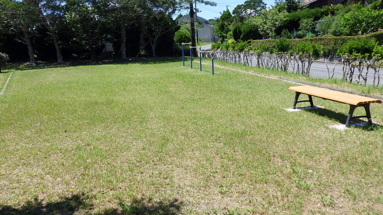 ねむのき公園のベンチ1台と鉄棒が写っています。