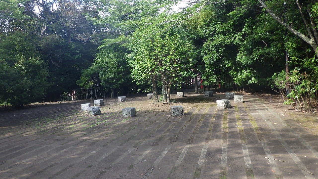 椿公園の入り口付近にある広場の写真です。椅子が12個ほど円状に広がっています。