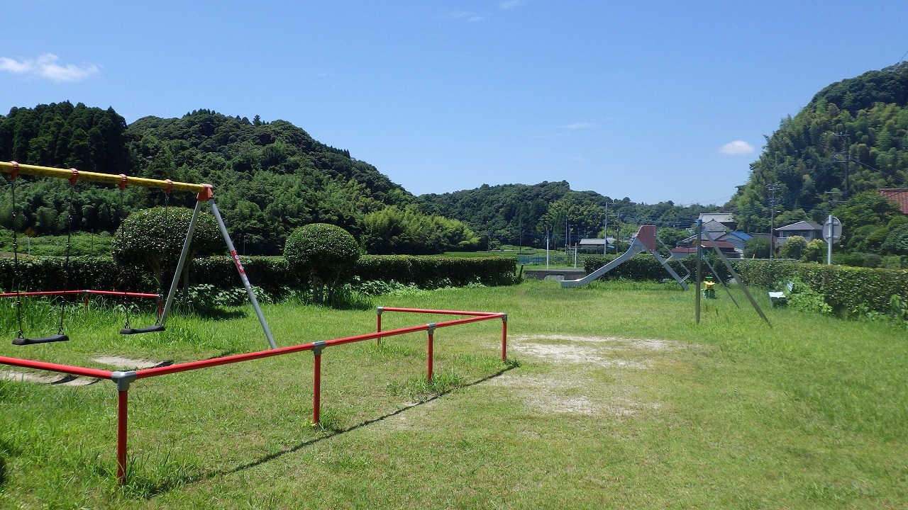 須賀谷児童公園のブランコ、鉄棒、すべり台が写っている写真です。