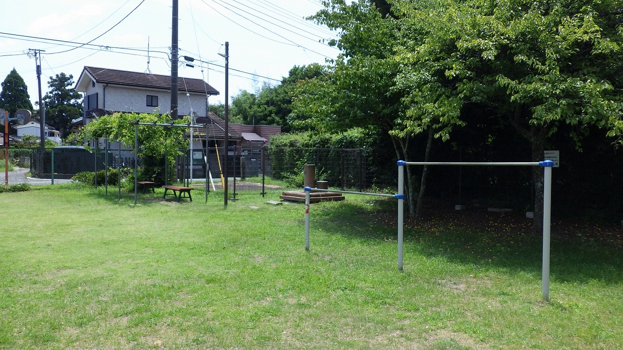 長者児童遊園の写真です。鉄棒、水道、ベンチが2台写っています。