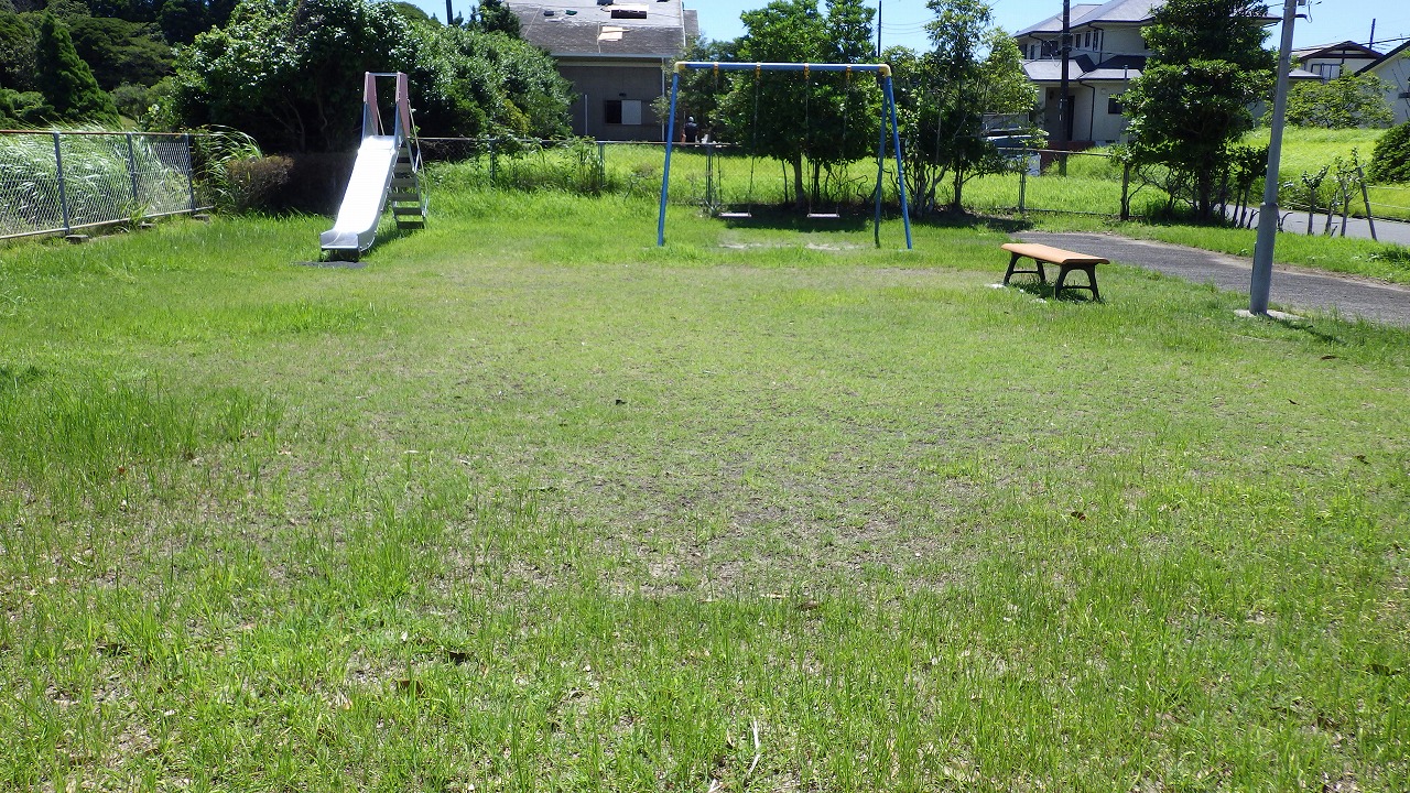 やしの木公園のベンチとブランコ、すべり台が写っています。