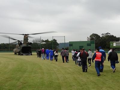 大勢の孤立した避難者たちが止まっているヘリコプターに向かって誘導されている避難訓練の様子を撮影した写真