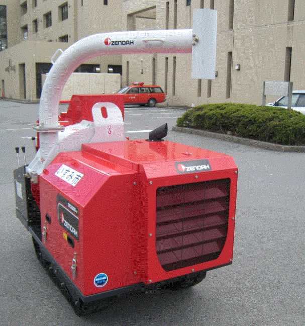 広い駐車場で、いすみ市と書かれた赤く四角い形をした車体に、逆さのL型をした大きなパイプがついて、前には操作レバーがついている粉砕機の写真